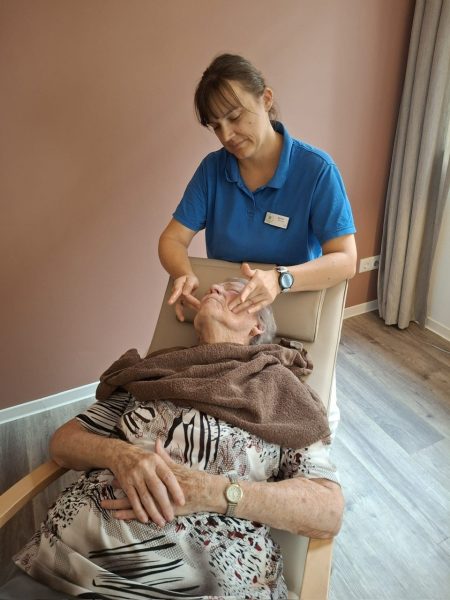 Mitarbeiterin verwöhnt Seniorin mit Gesichtspflege Leipzig