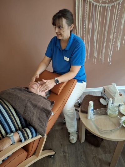 Mitarbeiterin pflegt Gesicht einer Seniorin in der Tagespflege Leipzig