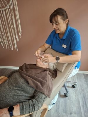 Seniorin erhält pflegende Gesichtsmaske in der Tagespflege Leipzig