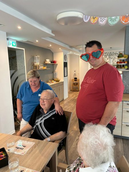 Pflegekraft und Angehöriger mit Spaßbrille beim Sommerfest in Leipzig-Stötteritz.