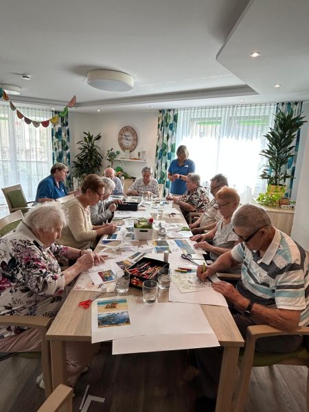 Senioren gestalten Collagen bei der Bastelrunde in der Tagespflege Leipzig-Stötteritz.