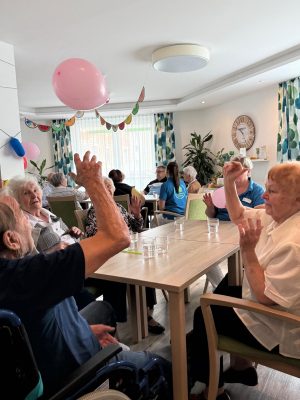 Senioren spielen mit Luftballons beim Sommerfest in der Tagespflege Leipzig-Stötteritz.