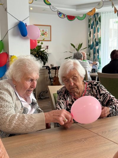 Zwei Seniorinnen spielen mit Luftballon beim Sommerfest in Leipzig-Stötteritz.