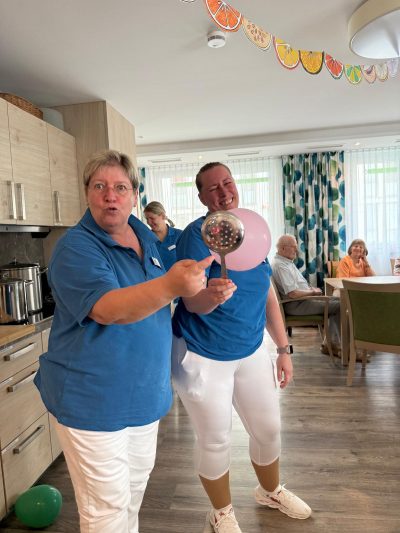 Pflegekräfte spielen mit Ballons und lachen beim Sommerfest Leipzig-Stötteritz.