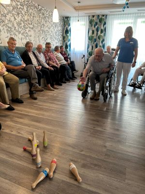 Senior im Rollstuhl spielt Kegeln in der Tagespflege Leipzig-Stötteritz.