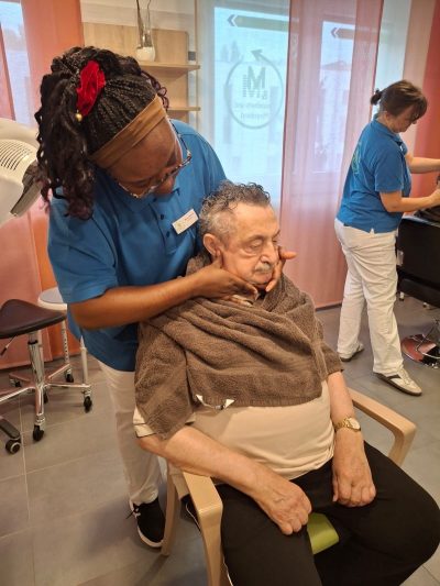 Senior erhält wohltuende Kopfmassage in der Tagespflege Leipzig-Stötteritz