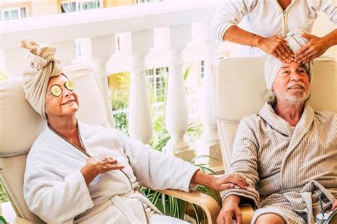 Senior erhält Gesichtsmassage in Tagespflege-Wellnesswoche, entspannt und glücklich