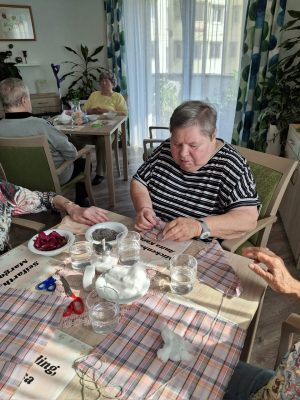 Seniorin schneidet Stoff für die Herstellung von Duftsäckchen in der Tagespflege Leipzig-Stötteritz.