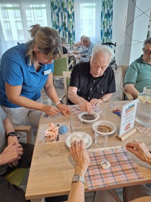 Senioren sitzen am Tisch und basteln Duftsäckchen in der Tagespflege Leipzig-Stötteritz.