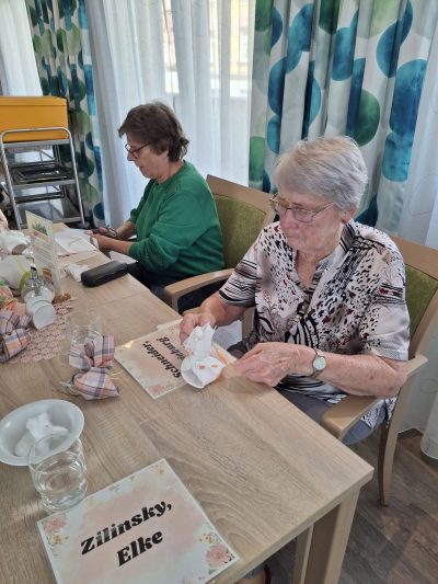 Senioren der Tagespflege in Leipzig-Stötteritz stellen gemeinsam Duftsäckchen mit Lavendel und Rosenblüten her.