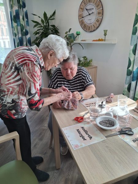 Seniorinnen gestalten in der Tagespflege Leipzig-Stötteritz Duftsäckchen aus Stoff und Lavendel.