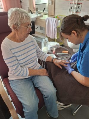 Seniorin genießt Nagelpflege durch Pflegekraft in der Tagespflege Leipzig-Stötteritz.