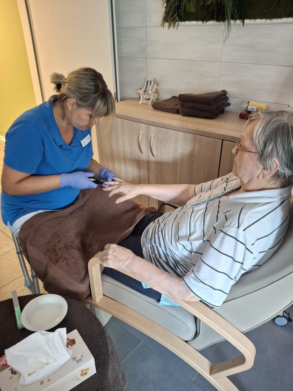 Bewohnerin erhält Nagelpflege von Pflegekraft im Pflegedienst Leipzig.