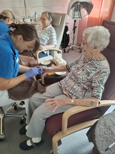 Seniorin lacht während einer Maniküre in der Tagespflege Leipzig.