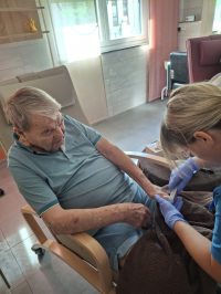 Senior erhält Nagelpflege durch Pflegekraft in der Tagespflege Leipzig.