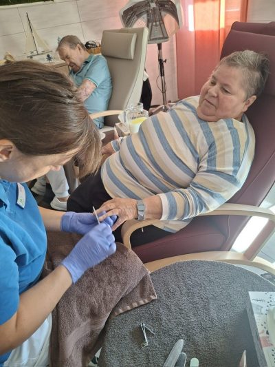 Seniorin entspannt während der Handpflege in der Tagespflege Leipzig.