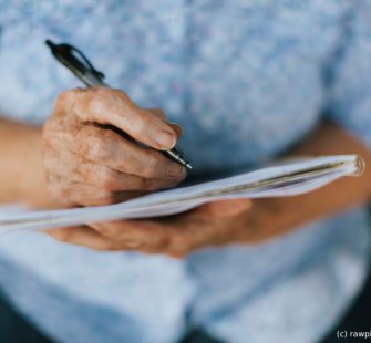 frau unterschreibt vollmachten im alter mit hilfe des m&m pflegedienstes